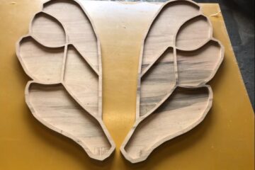 Image depicts previous CNC machining work by CreativeCNC. Product shown is a trinket tray in the shape of angel wings. The wood is thick and good quality and the tray is precisely divided into sections.